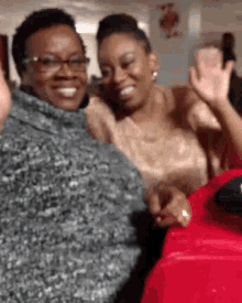two women are posing for a picture and smiling for the camera .