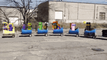 a toy train is going down a road with a building in the background