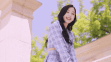 a woman in a plaid shirt and skirt is smiling