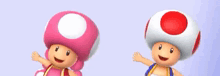 a pink toad and a red toad are standing next to each other .