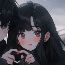 a boy and a girl are holding hands and making a heart shape with their hands .