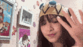 a girl wearing a crocheted crown waves her hand