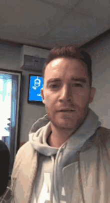 a man wearing a hoodie with the letter a on it looks at the camera