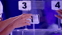 a person is playing a game with numbers 3 and 4 on the display