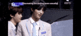 a man in a suit and tie is recreating the ending pose casually while another man looks on