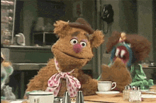 two muppets are sitting at a table with cups and salt and pepper shakers