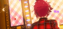 a man with red hair is standing in front of a screen .