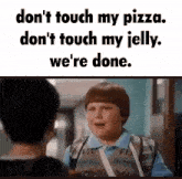 a boy with a bandage on his arm is talking to another boy in a hallway while holding a pizza ..