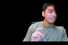 a man in a green shirt is smiling and making a funny face