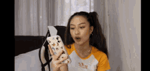 a woman is holding a phone case with butterflies on it in her hand .