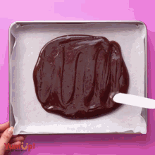 a person is spreading chocolate on a baking sheet with a spatula from yumup
