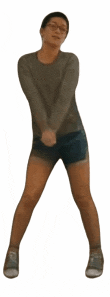 a woman wearing shorts and a sweater is dancing