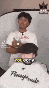 a man in an alaska shirt is giving a haircut to a boy