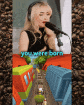 a woman singing into a microphone next to a picture of a train that says you were born