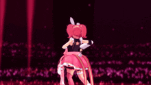 a girl with pink hair and a flower on her back is standing in front of a crowd