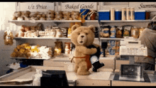 a teddy bear is hugging another teddy bear in a store with baked goods on the shelves