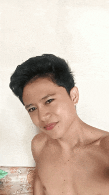 a shirtless young man is taking a selfie with his phone