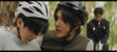 a man wearing a helmet talks to another person