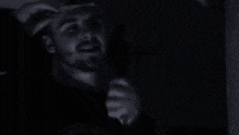 a man wearing a zombie hill t-shirt is standing in the dark