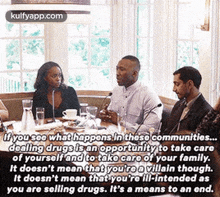 a group of people are sitting around a table having a conversation .