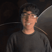 a man wearing glasses and a black shirt with the word elliot on it