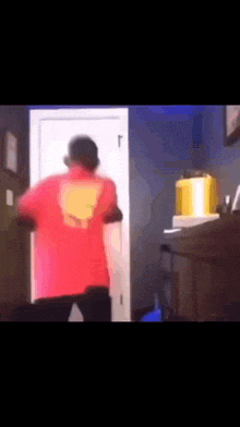 a man in a red shirt is standing in a doorway .