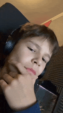 a young boy is wearing headphones and making a funny face