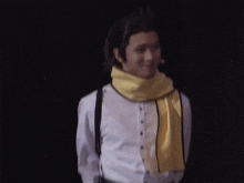 a man wearing a yellow scarf around his neck and suspenders