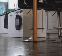 a kitchen with a washer and dryer and a bar stool