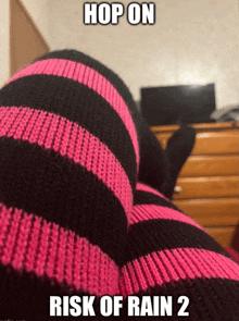 a pair of pink and black striped socks with the words hop on risk of rain 2