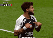 a soccer player wearing a shirt that says esporte da sorte is pointing at his chest