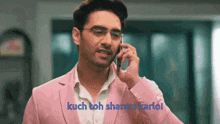 a man in a pink jacket is talking on a cell phone .