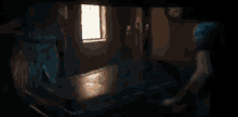 a statue of a man with a beard is standing in a dark room in front of a window .
