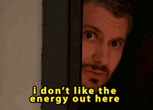 a man peeking out from behind a door with the words i don 't like the energy out here above him