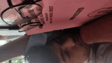 a person wearing glasses laying on top of a pink paper that says ' birth record '