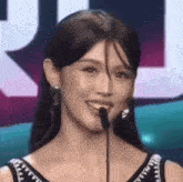 a close up of a woman smiling into a microphone .