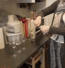 a woman is opening a bottle of coca cola on a counter