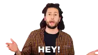a man with a beard is wearing a plaid shirt and black shirt