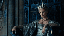 a woman wearing a crown sits in a chair