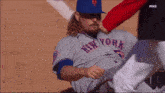 a man wearing a new york jersey is being helped off the field