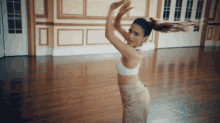 a woman in a crop top is dancing in a room