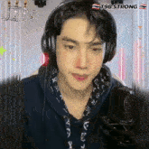 a young man wearing headphones stands in front of a microphone with the name jin on the bottom right