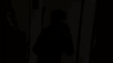 a man wearing a black nike shirt is standing in a hallway