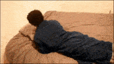 a person laying on a bed with a blue blanket