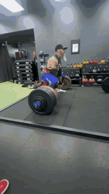 a man lifting a barbell in a gym with a motorcycle in the background