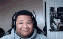 a man wearing headphones is smiling in front of a door that has call of duty posters on it