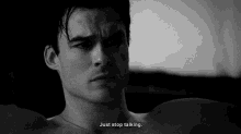 a black and white photo of a shirtless man with the words just stop talking below him