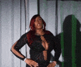 a woman with red hair is wearing a black dress