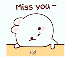 a cartoon seal is sitting on a table with the words `` miss you '' written above it .