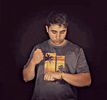 a man wearing a t-shirt with palm trees on it is looking at his watch